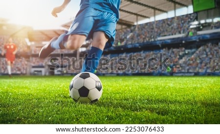 Football World Championship: Soccer Player Runs to Kick the Ball. Ball on the Grass Field of Arena, Full Stadium of Crowd Cheers. International Tournament Concept. Cinematic Shot Captures Victory.
