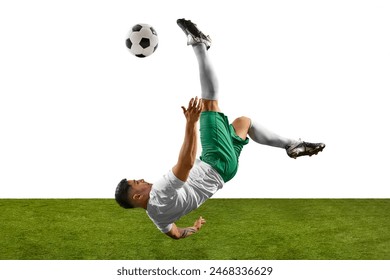 Footballer performing dramatic overhead kick, with his body upside down and ball in motion against white backdrop and grassy field. Concept of professionals sport, competition, tournament, energy. Ad - Powered by Shutterstock