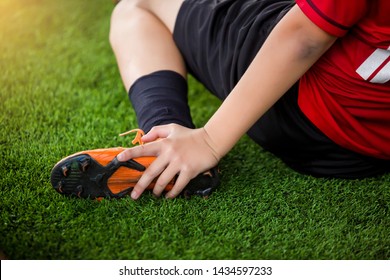 footballer is sitting and catch the ankle of the feet because of pain, soccer player was injured in the foot with pain during competition or practice. - Powered by Shutterstock