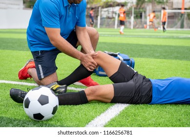 Footballer wearing a blue shirt, black pants injured in the lawn during the race. - Powered by Shutterstock