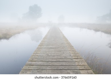Footbridge Ends In A Foggy Landscape 
