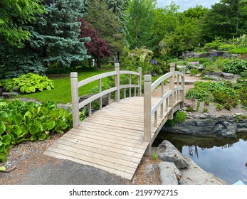 Footbridge Over Brook. Flowery Brook Garden In Montreal Botanical Garden. Flowerbeds Laid Out In Typical English Style, Unconstrained By Symmetry Or Straight Lines. Montreal Botanical Garden.