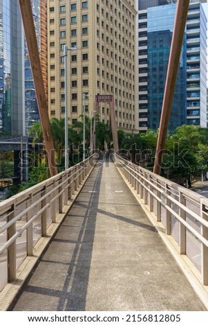 Footbridge for pedestrian crossing under the busy avenue. Symmetrical image. Richest region of the city of São Paulo.