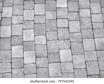 Foothpath gray brick tile texture background.