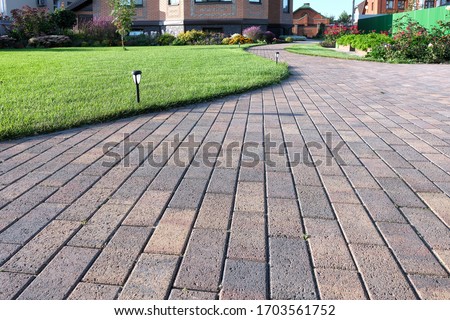 Footpath in the flower garden. Paving stones and lush lawn. Landscaping in a country cottage.