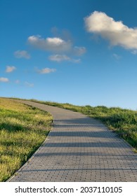 Footpath With Gentle Slope Turns Left On Green Hill Under Blue Sky