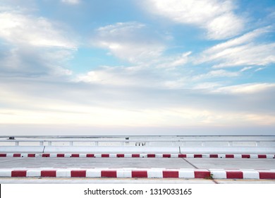 Footpath Road. Red And White Concrete Sidewalk Curb On Blue Sky Blackground. Signs On A Road.