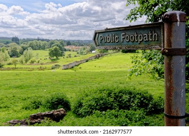 Footpath sign pointing over a traditional hay meadow in Chipping Campden, Gloucestershire, England, United Kingdom.