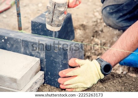 Footpath under construction. Builder installing new kerbs on concrete close-up