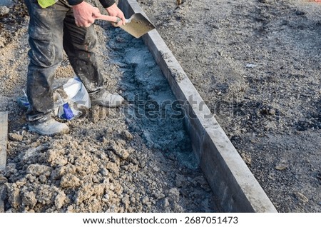Footpath under construction. Builder installing new kerbs on concrete