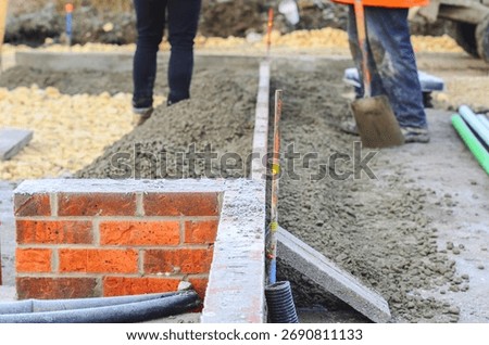 Footpath under construction. Builder installing new kerbs on concrete