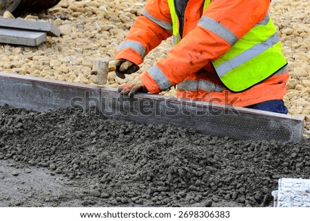Footpath under construction. Builder installing new kerbs on concrete