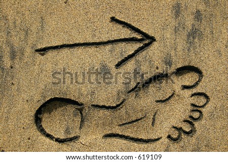 Footprint outline and arrow in the sand