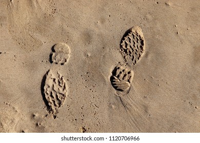Footprints in beach sand facing opposite directions. This image can used to represent the concept of changing direction. 
