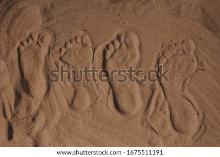 the footprints of family members in the sand