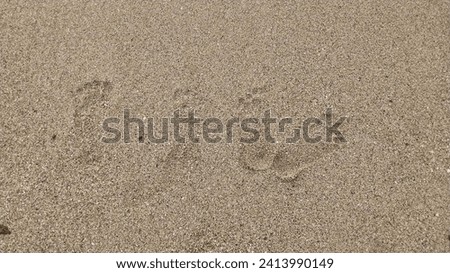 Footprints of a husband and wife on the white sand of the beach. Simple romantic holiday background concept