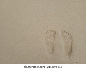 footprints on the beach sand for the background of small notes, motivation, aphorisms, quotes