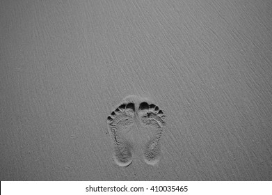 footprints in sand on the beach, black and white