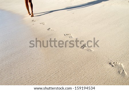 Footprints in wet sand of beach