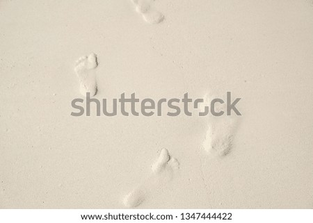 Footprints in the wet white sand
