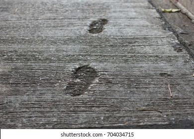 foots prints on a concrete street