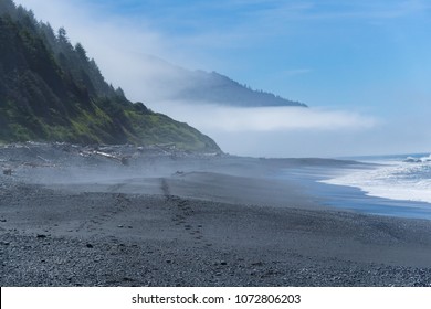 Footsteps in the black sand of the Lost Coast backpacking trail in California