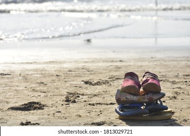 Footwears Kept On Beach Of A  Nuclear Family.