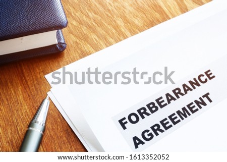 Forbearance agreement papers with pen and notepad.