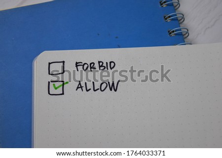 Forbid and Allow write on a book. Supported by an additional services isolated wooden table.