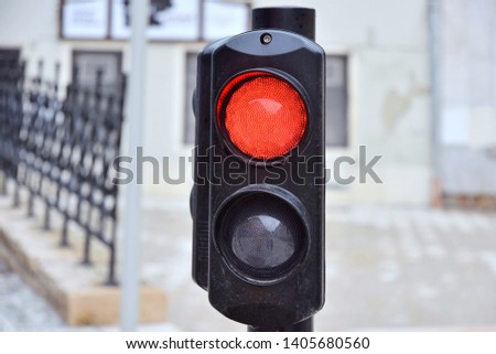 Forbidden red traffic light on blurred city street background. Warning red traffic sign. Red traffic signal prohibiting traffic. Regulation semaphore for city road. Red stoplight. Caution stop ligh