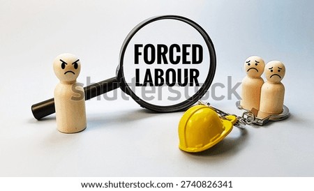 Forced Labour concept viewed through magnifying glass, symbolizing worker exploitation, human rights violation, coercion, modern slavery and labor abuse investigation. 