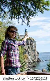 Forced Perspective View Of A Pretty Female Appearing To Be Holding The Split Rock Lighthouse In Minnesota With Her Hands