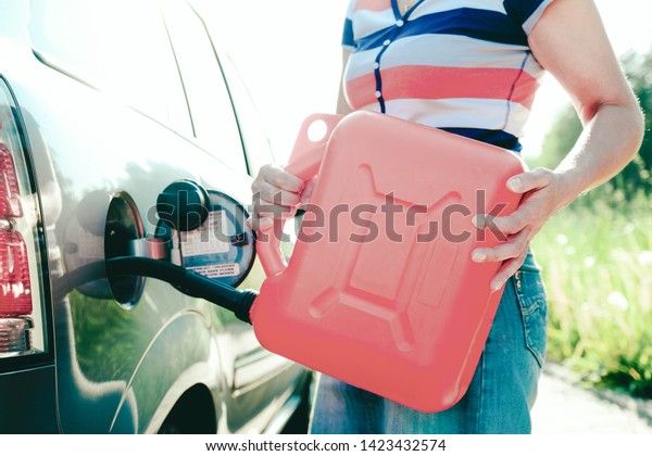 Forced stop. Ran out of gas in the tank of the\
car. A woman fills the car with gasoline from a spare tank.\
Canister of 10 liters.