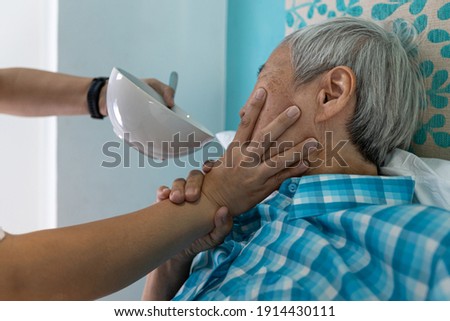 Force-feeding,Asian senior woman refuses,does not want to eat food,caregiver scolding,forcing the elderly to eat,old people with no appetite,stop physical abuse,violence,aggression,coercion concept