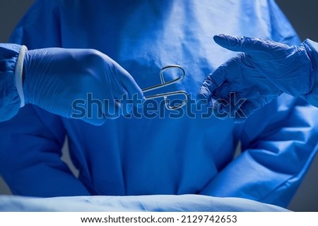 Forceps please. Closeup shot of group of surgeons working on a patient in an operating room.