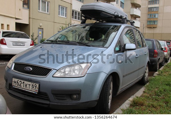 Ford Focus C-Max is compact multi-purpose vehicle\
(MPV) produced by Ford Motor Company. Car with luggage box Thule\
roof. american family multivin. Vehicle is parked on street. Moscow\
2013 trunk, boot
