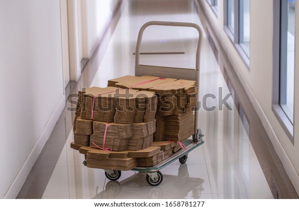 Fordable platform hand truck with cardboard\
box. goods sale. commerce, post box online shopping. Purchasing\
power, delivery order. E-commerce, sales and sale of goods through\
online trading\
platforms.
