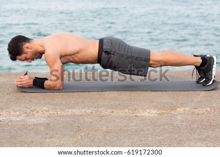Forearm plank exercise outside close to the beach