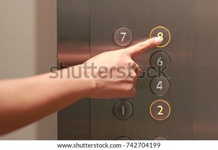 Forefinger pressing the eighth floor button in the elevator