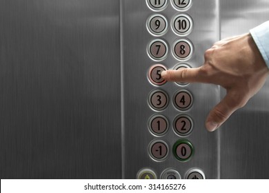 Forefinger pressing the fifth floor button in the elevator