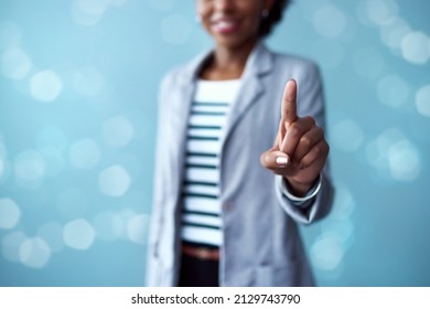 At The Forefront Of Cutting Edge Tech. Cropped Studio Shot Of A Young Businesswoman Touching An Interface Against A Blue Background.