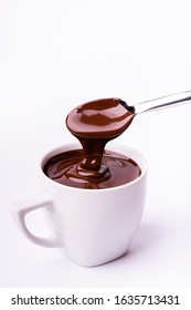 In The Foreground, A Spoonful Of Hot And Thick Chocolate