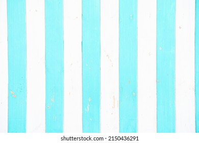 in the foreground there are white and turquoise stripes made of wood                         