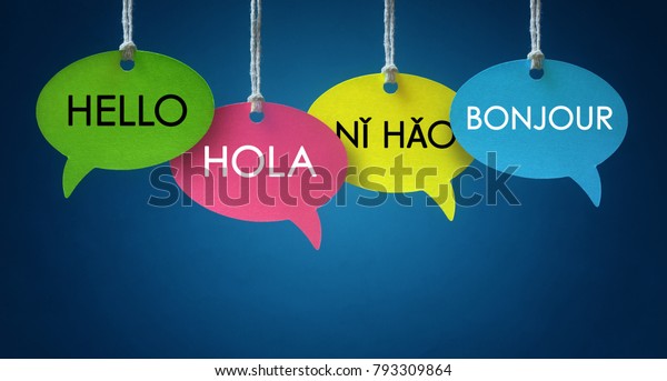 Foreign language colorful\
communication speech bubbles hanging from a cord over blue\
background