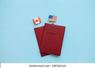 Foreign Passport With The Flags Of The USA And Canada On A Blue Background. The Concept Of Migration, Work And Travel.