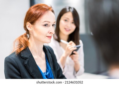 A Foreign Woman Speaking At A Conference With Her Interpreter