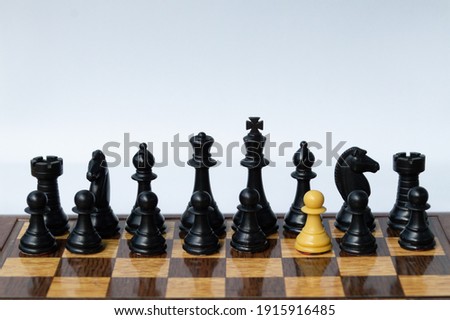 A foreing pawn in a chess set on a chess board