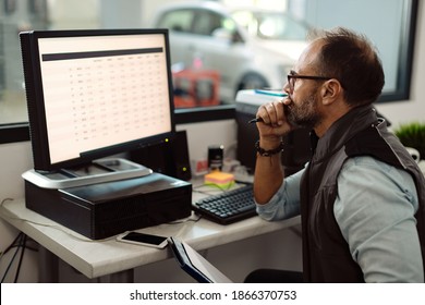 Foreman Of Auto Mechanic Workshop Using Desktop PC In The Office. 