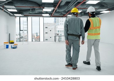 Foreman and builder checking office building under construction