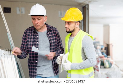 Foreman and builder counting construction materials in building site.